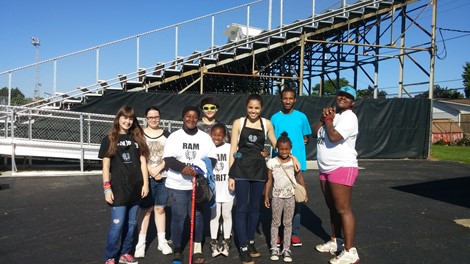 Key Club members cleaning up the stadium after a football game.